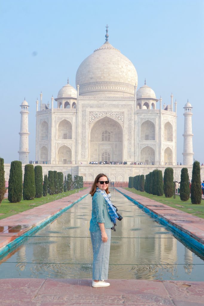 The white marble Taj Mahal reflected in still water at sunrise in Agra, India