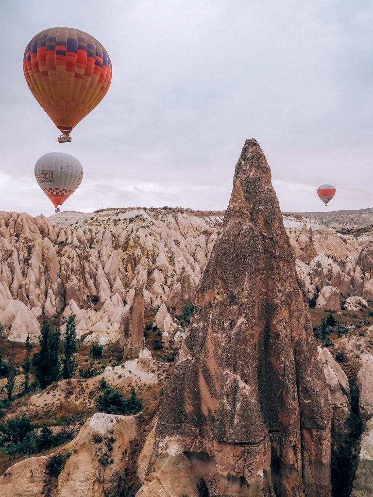 cappadocia at sunrise with balloons flying over